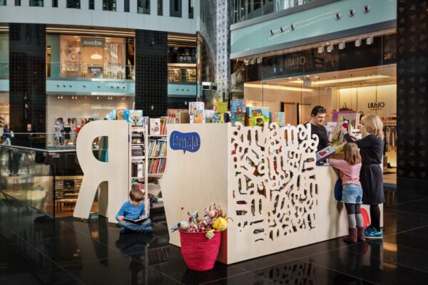 Lamala is a bookshop stall, where you can buy books and toys for children. Openwork walls are inspired by the typography used in the Lamala logotype.