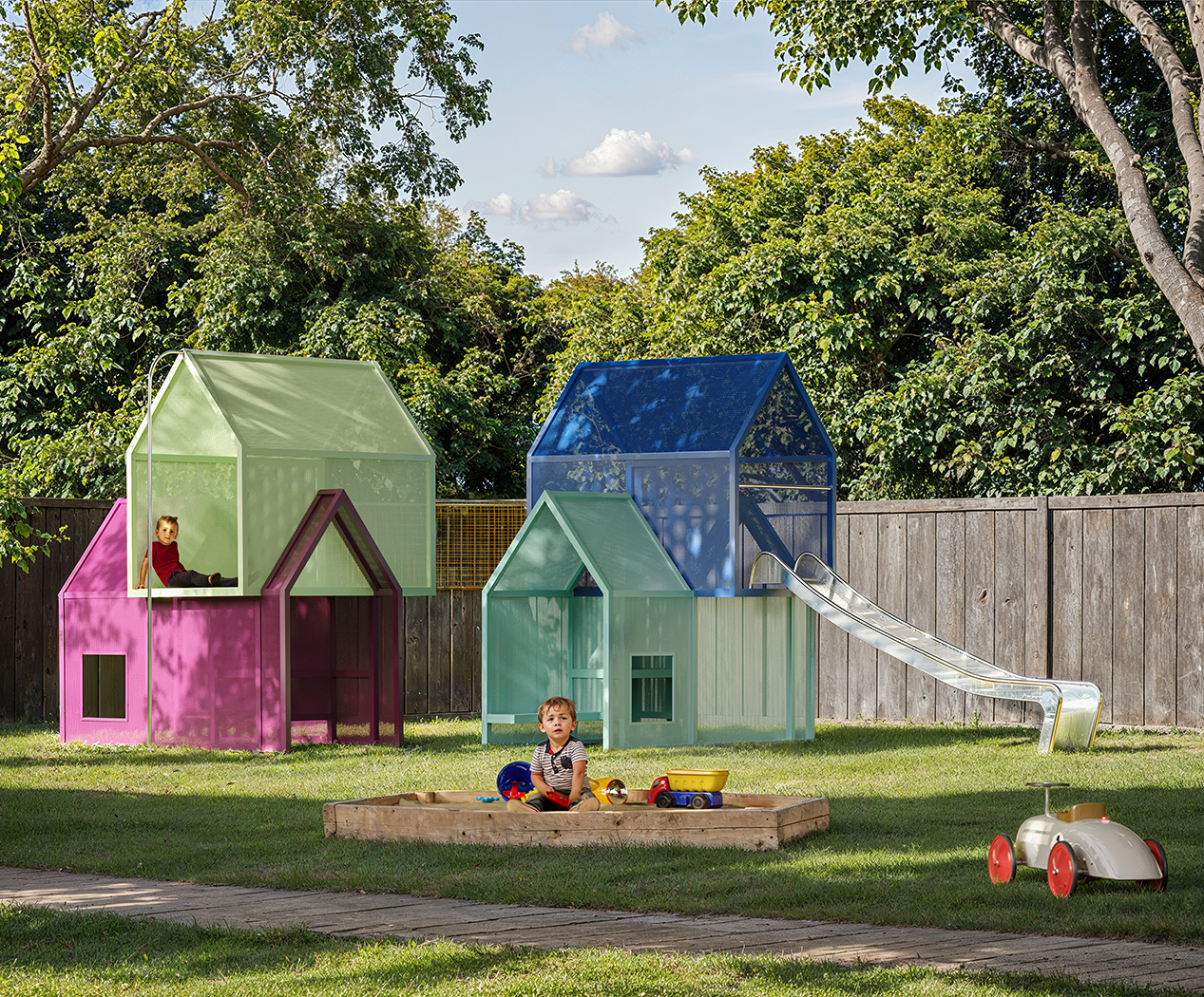 Escultura lúdica: casas apiladas que invitan a los niños a explorar, esconderse y jugar creativamente.
