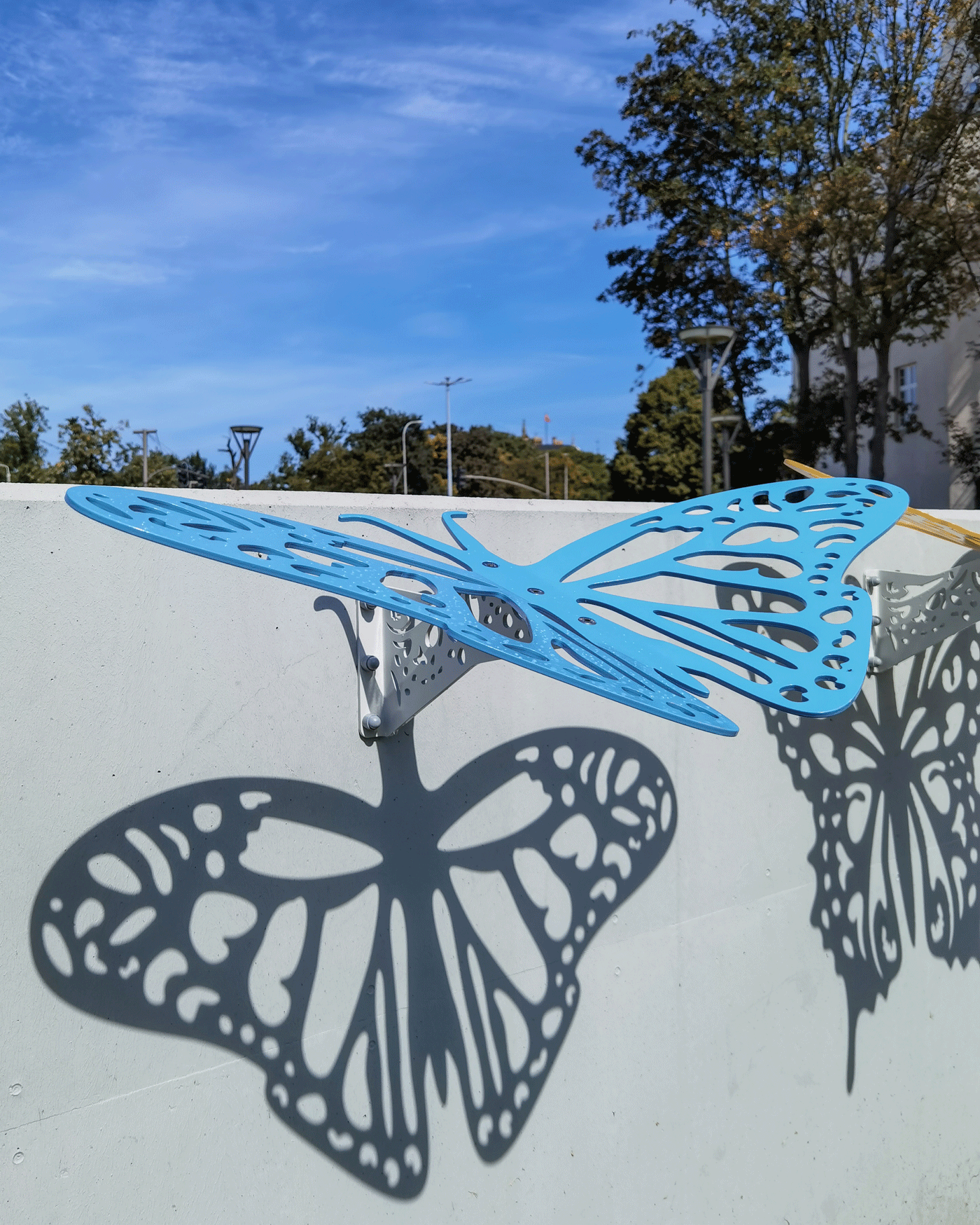 Offbeat outdoor wall features in the shape of insects that cast shadows onto the wall